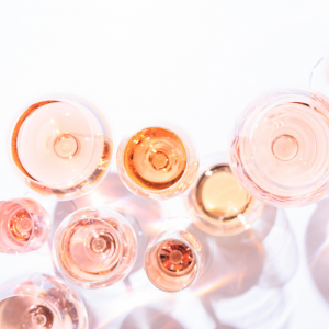 Numerous wine glasses filled with pink liquid