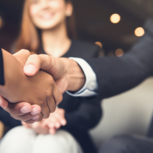 a man and woman shaking hands completing a job interview.
