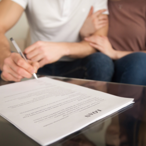Two people signing a loan document.