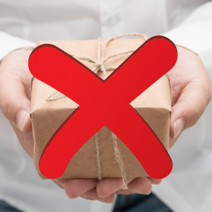 A woman in a white shirt holding a small present wrapped in brown paper with a large red X over the package. Avoid Holiday Travel Stress