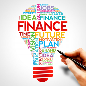 A light bulb filled with financial words, goals, finance, idea, data. A hand with a pen is below. Jump Start 2020 Financial Resolutions