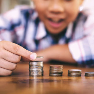 A kid in a plaid shirt counting coins