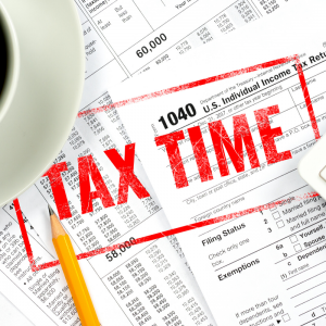 A coffee cup sitting on a pile of tax documents | Tax Time