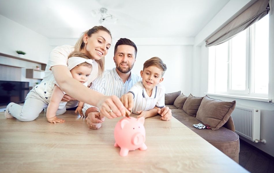 Family putting money into a piggy bank