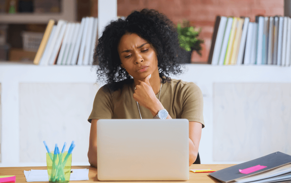 Woman thinking while looking at her laptop
