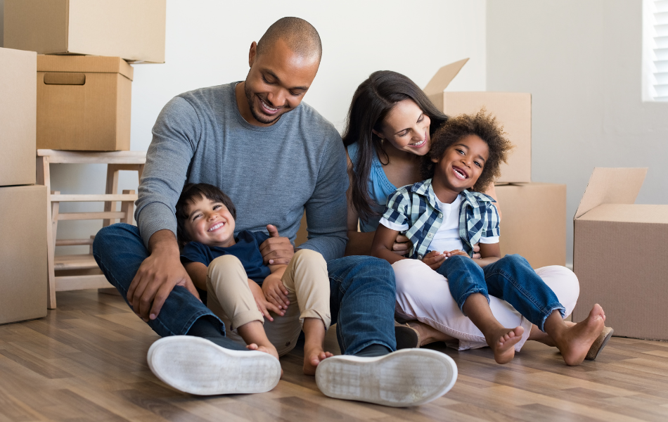 Family sitting on the floor of their new home- Mortgage
