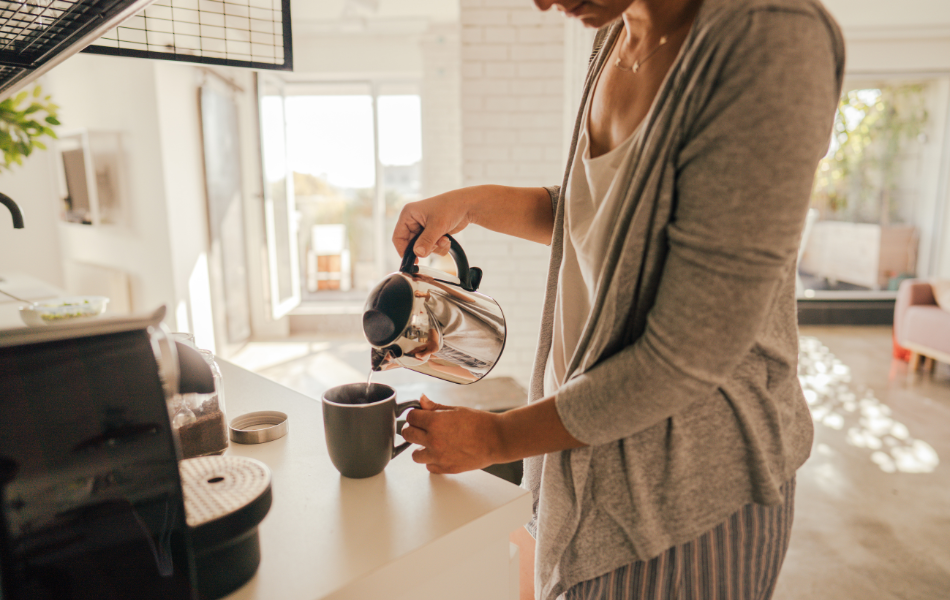 Person pouring a cup of coffee at home.