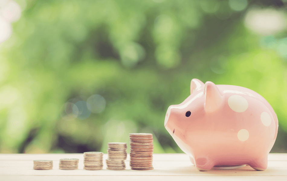 Piggy bank with stacks of coins next to it.