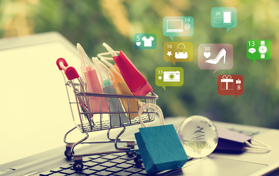Small shopping cart filled with shopping bags on top of a laptop