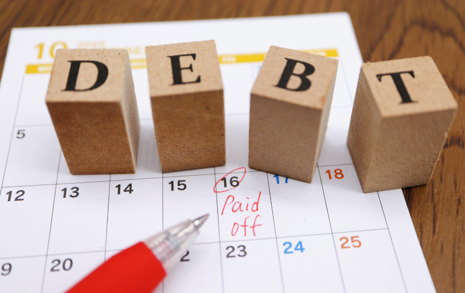 Pay Off Debt - building blocks spell out the word Debt while sitting on a calendar.