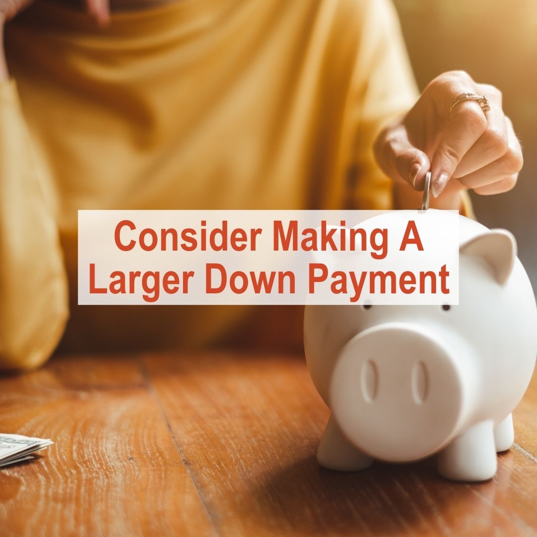 Woman putting quarter into piggy bank | Consider Making A Larger Down Payment